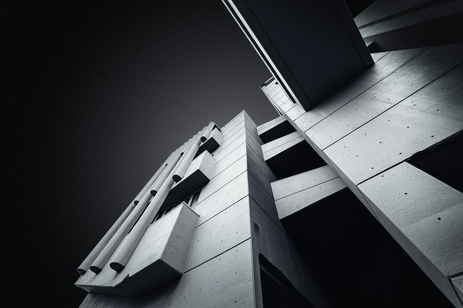 Concrete building blocks rising against a dark sky, in black and white