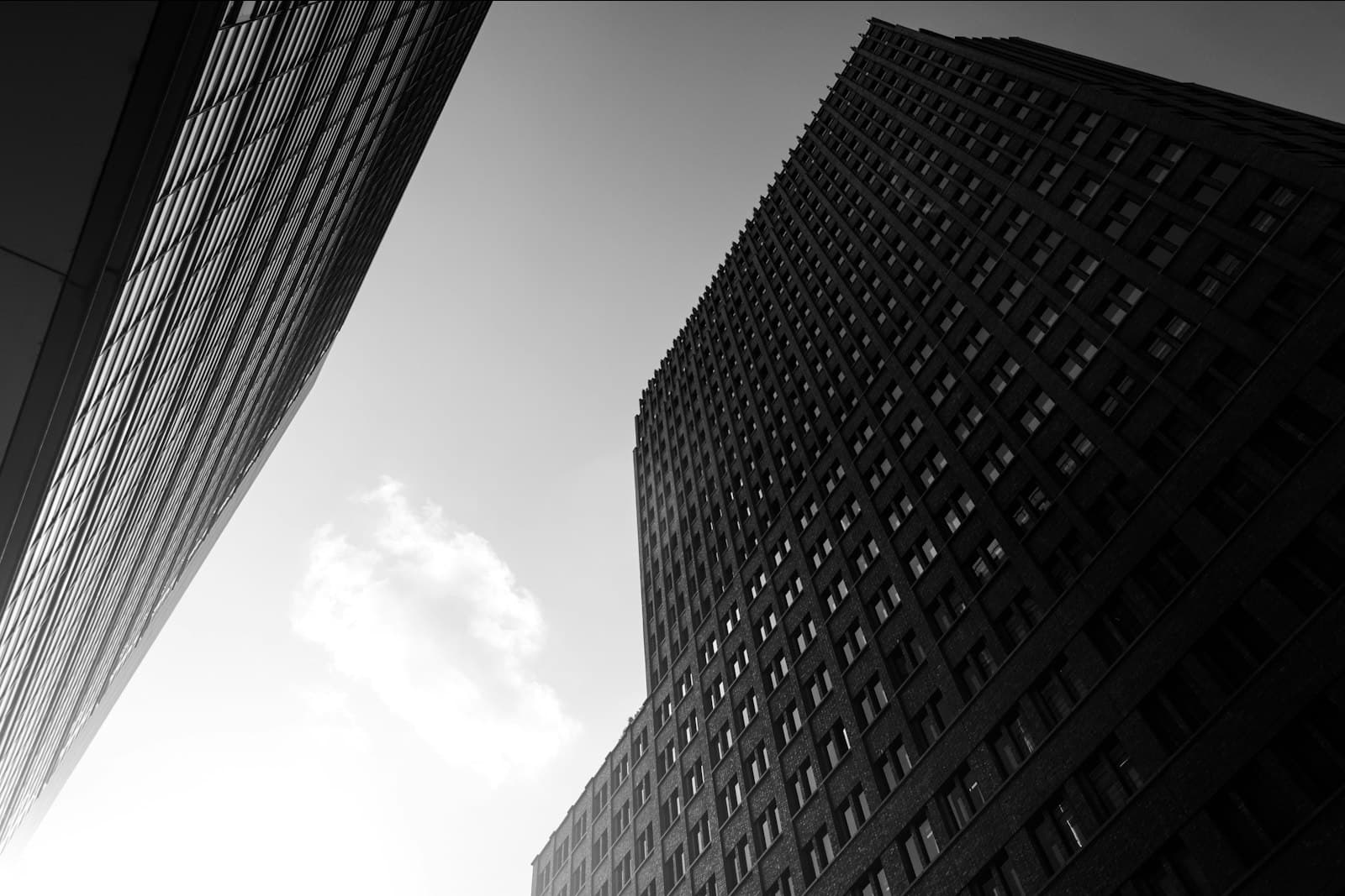 Two high-rise towers seen from the street, in black and white