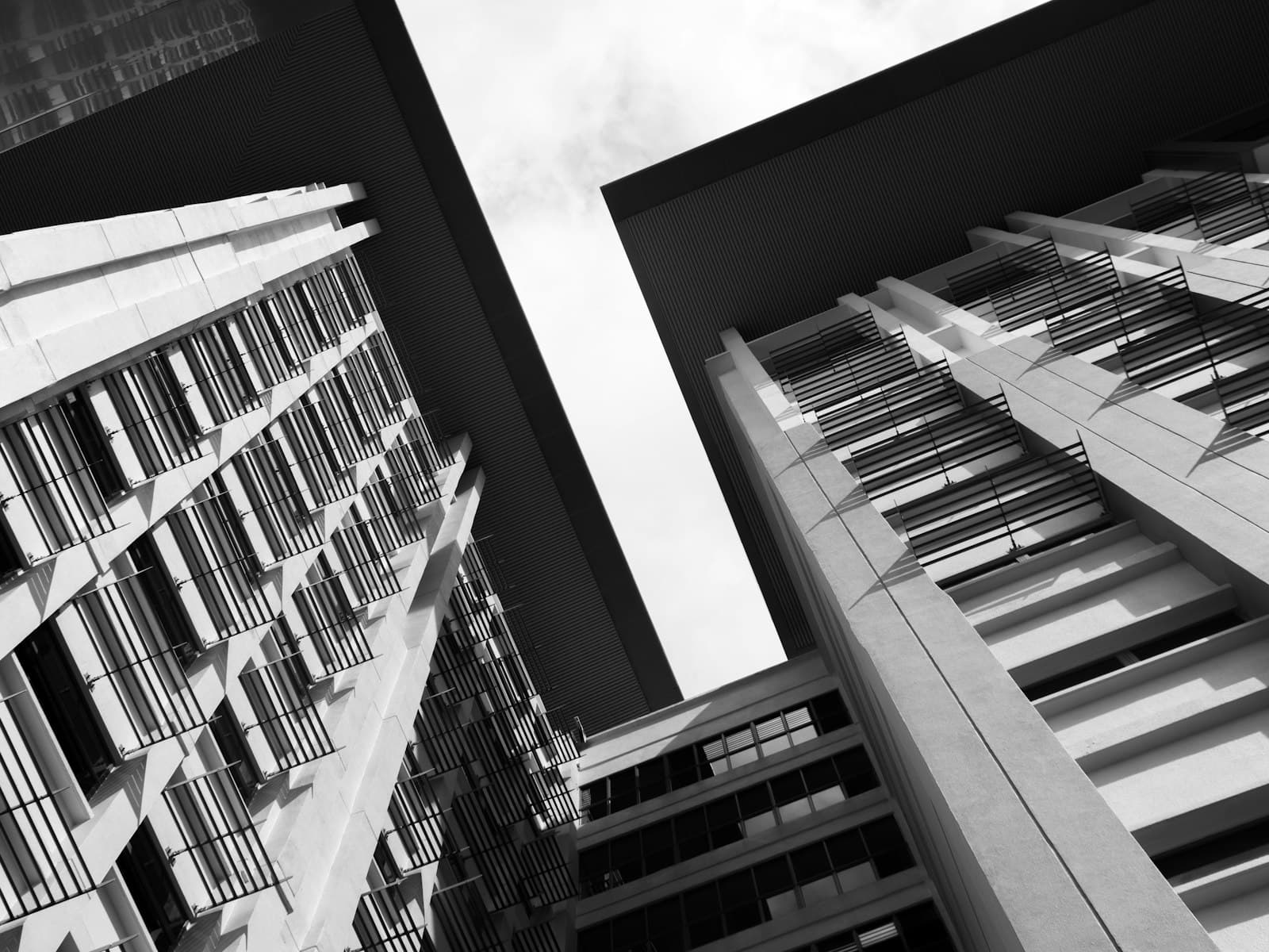 Two modern buildings with balconies seen from below